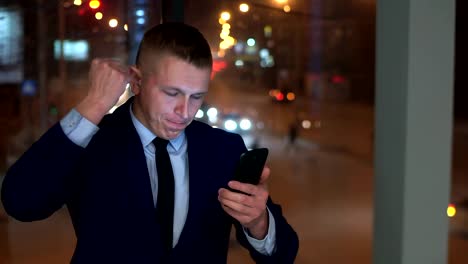 The-man-is-a-businessman,-looking-at-the-smartphone-and-angry,-trying-to-contain-anger.