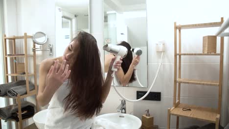 Hair-Care.-Frau-trocknen-lange-Haare-mit-Fön-im-Badezimmer