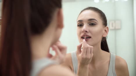 Maquillaje.-Mujer-aplicar-lápiz-labial-líquido-en-boca-en-el-baño