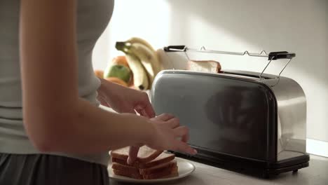 Frühstück.-Frau,-setzen,-schneiden-Brot-im-Toaster-Closeup