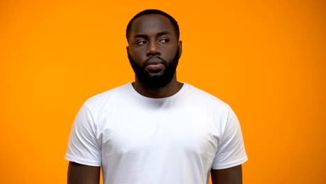 African-American-man-showing-silence-gesture,-keeping-secret,-yellow-background