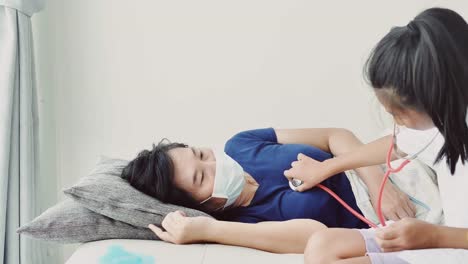 Asiatische-Mädchen-in-Arztuniform-behandeln-ihre-Mutter-zu-Hause,-Lifestyle-Konzept.