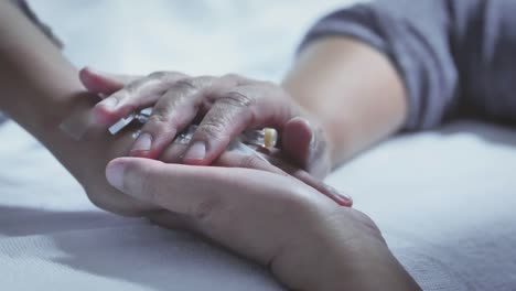 Mother-holding-hand-of-his-son-sick-bed-in-the-hospital.-Touch-the-hand-Slow-motion.-care-encouragement