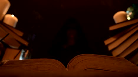 Close-up-of-a-contented-girl-magician-in-a-dark-room-by-candlelight-conjured-herself-a-cake.-Holds-a-plate-of-cake-Low-key-live-camera.