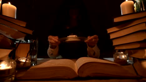 Close-up-of-a-contented-girl-magician-in-a-dark-room-by-candlelight-conjured-herself-a-cake.-Holds-a-plate-of-cake-Low-key-live-camera.