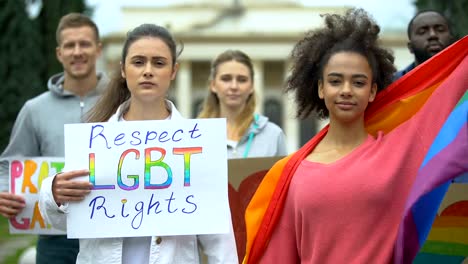 Gruppe-von-Menschen,-die-Regenbogenfahnen-hissen,-Plakate-für-LGBT-Rechte,-Gleichstellung-der-Geschlechter