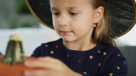 Girl-trying-to-draw-really-scary-face-on-halloween-pumpkin