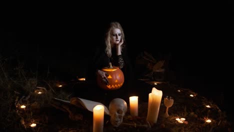 Halloween-Bild.-Junge-Hexe-in-schwarzer-Kleidung-hält-Kürbis-in-ihren-Händen.