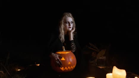 Halloween-Image-.Young-Witch-In-Black-Clothes-Holds-Pumpkin-In-Her-Hands.