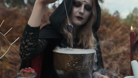 Halloween.-Young-Witch-Spells-At-The-Table.