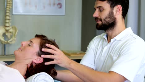 Physiotherapeuten,-die-eine-Frau-Kopfmassage-verleihen