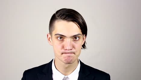 Close-up-of-young-adult-man-full-of-fury,-looking-at-the-camera.-Swears