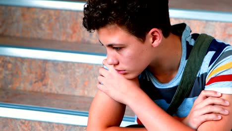 Sad-schoolboy-sitting-alone-on-staircase