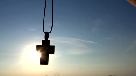 Closeup-Of-Silhouette-Cross-Hanging-at-sunset/sunrise-time