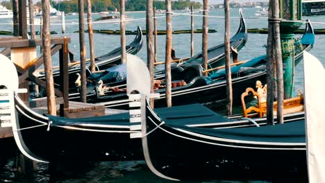 Soporte-de-góndolas-negras-hermosas-y-roca-en-las-olas-del-Gran-Canal-en-Venecia