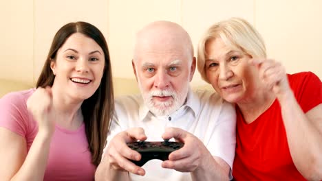 Senior-couple-and-daughter-gamers-playing-video-game-at-home.-Happy-family-enjoying-time-together