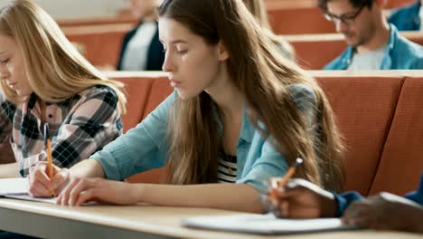 A-Row-of-Multi-Ethnic-Students-in-the-Classroom-Taking-Exam/-Test/-Writing-in-Notebooks.-Bright-Young-People-Study-at-University.