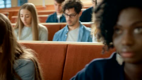 Fila-de-Multi-étnica-de-estudiantes-en-el-aula-de-examen-/-prueba-/-escribir-en-cuadernos.-Brillantes-jóvenes-estudio-en-la-Universidad.