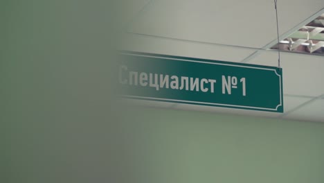 Green-plastic-sign-under-ceiling-with-russian-text-sais-specialist-number-one