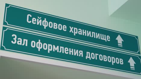 Green-plastic-signs-on-wall-russian-text-sais-safe-depository-and-meeting-room