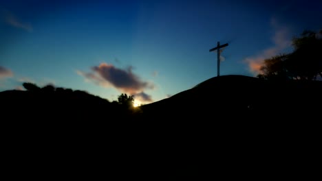 Mujer-rezando-en-la-Cruz-de-Jesús,-puesta-de-sol,-panorámica,-4K