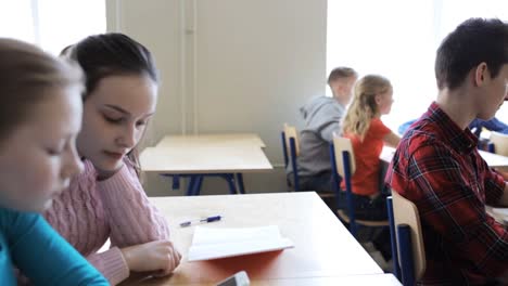 estudiantes-con-smartphone-en-la-lección-en-la-escuela