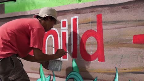 Mural-painter-draws-a-letter-l-on-school-wall.-time-lapse