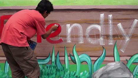 Mural-painter-draws-a-letter-e-on-school-wall.-time-lapse