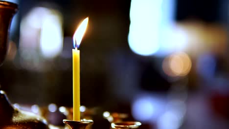 Una-persona-pone-una-sola-vela-en-el-altar-de-una-iglesia-ortodoxa