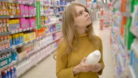 Young-women-choosing-household-chemicals-in-supermarket.