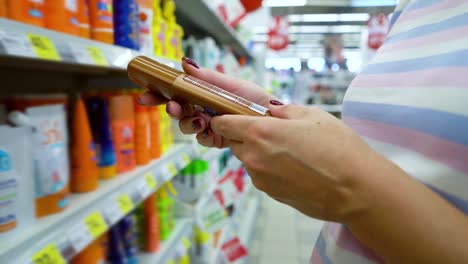 Closeup-caucasian-woman-near-shop-shelves-choosing-cosmetics-in-market