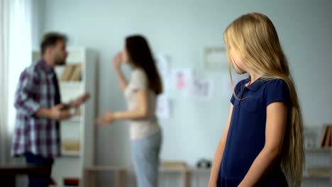 Frightened-girl-nervously-twisting-fingers,-scared-by-parents-quarrel,-violence