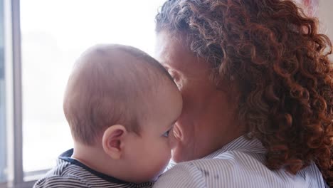 Nieto-de-bebé-mirar-por-encima-del-hombro-de-abuelas-como-ella-lo-abraza