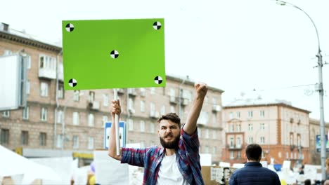 Alboroto-en-la-ciudad.-Un-chico-con-un-cartel-en-blanco-en-sus-manos-para-su-título-lenta