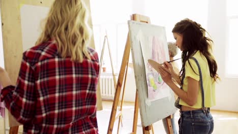 students-with-easels-painting-at-art-school