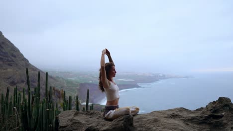 Woman-meditating-on-top-of-a-rock-at-the-mountains-at-sunrise.-Practice-yoga-on-outdoor.