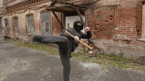 Violent-bandit-training-with-baseball-bat-making-kick-to-camera