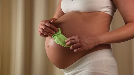 Pregnant-woman-touching-her-belly-with-hands