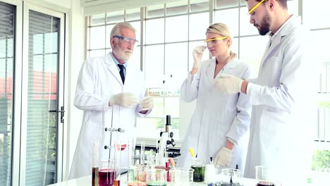 Science-teacher-and-students-team-working-with-chemicals-in-lab