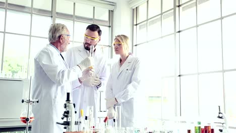 Science-teacher-and-students-team-working-with-chemicals-in-lab