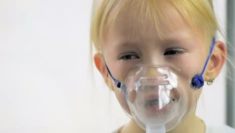 Nahaufnahme-von-einem-vier-jährigen-Mädchen-in-einer-Maske-Atemgas-durch-einen-Inhalator-im-Krankenhaus-in-Zeitlupe.