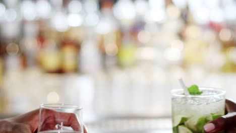 Close-Up-Of-Hands-Holding-Beer-And-Cocktail-Making-A-Toast-In-Bar