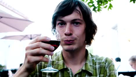 Man-on-a-date-raises-a-glass-of-wine-and-clink-glasses.-Guy-in-love-smiles-in-a-restaurant-at-dinner