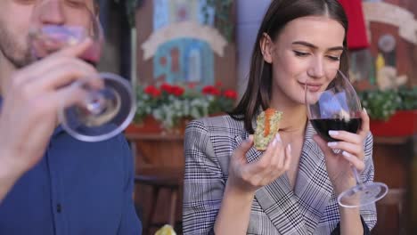 Couple-Drinking-Red-Wine-And-Eating-Food-In-Restaurant-Closeup