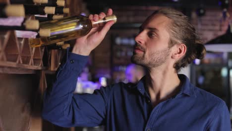 Wine-Restaurant.-Handsome-Man-Choosing-Wine-Bottle-On-Shelf