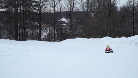 Kleines-Mädchen-reitet-auf-einem-Rodeln-Snowtubing-in-Sibirien