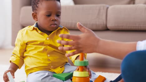 madre-y-el-bebé-jugando-con-bloques-de-juguete-en-casa