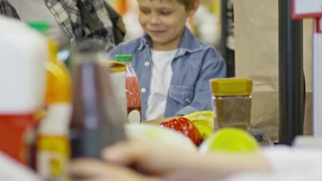 Family-Putting-Products-on-Conveyor-Belt-at-Checkout