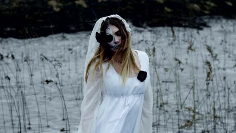 A-woman-with-spooky-make-up-for-Halloween-in-a-white-bride-dress.-Slow-motion.-HD