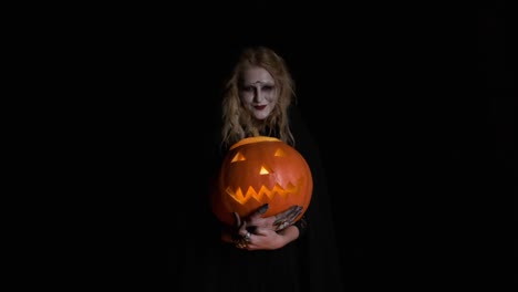 Halloween-Image-.Young-Witch-In-Black-Clothes-Holds-Pumpkin-In-Her-Hands.